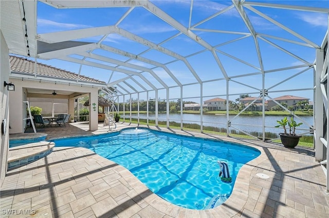 outdoor pool featuring glass enclosure, a water view, and a patio area