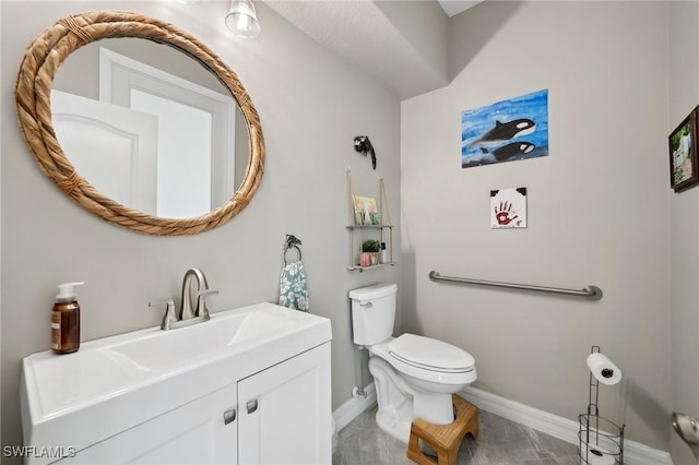 half bathroom featuring baseboards, toilet, and vanity