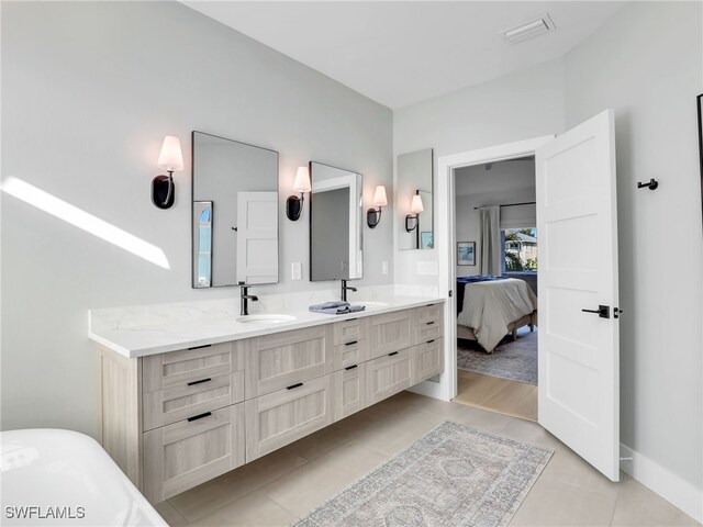 ensuite bathroom with tile patterned floors, visible vents, a sink, connected bathroom, and double vanity