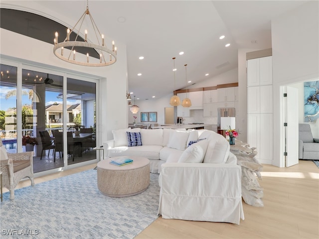 living room with recessed lighting, light wood-type flooring, a chandelier, and high vaulted ceiling