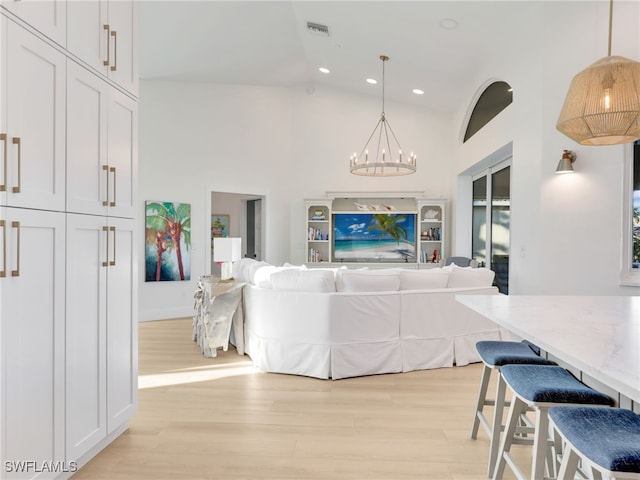 living area with visible vents, high vaulted ceiling, light wood-style flooring, recessed lighting, and a chandelier