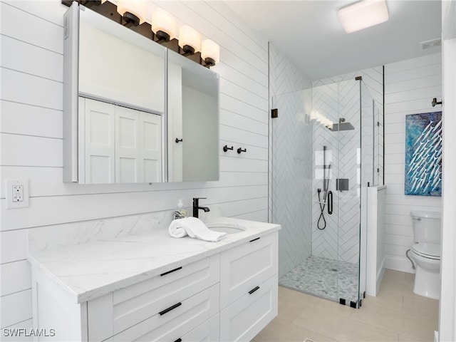 full bathroom with vanity, a stall shower, wood walls, tile patterned floors, and toilet