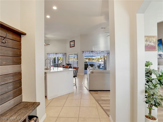 hall featuring sink and light tile patterned floors