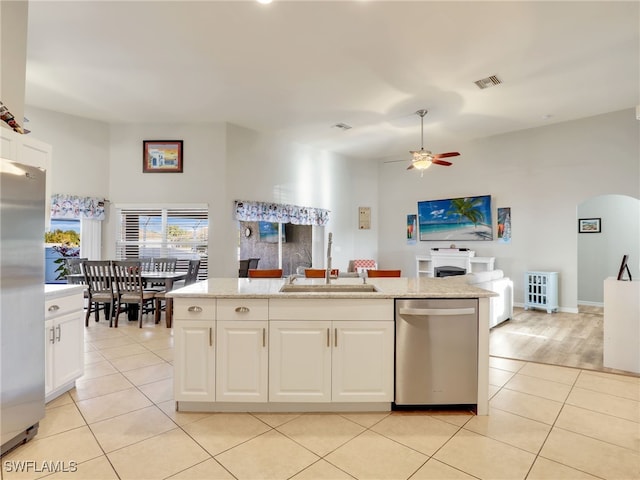 kitchen featuring sink, light tile patterned floors, white cabinetry, stainless steel appliances, and a center island