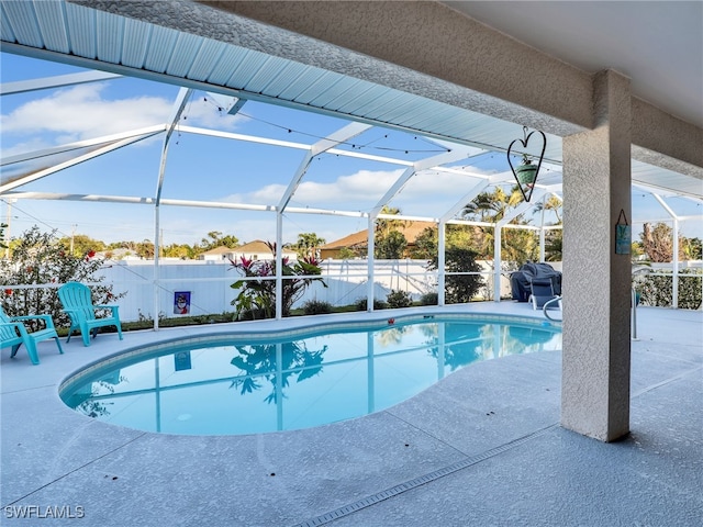 view of swimming pool featuring a patio and glass enclosure