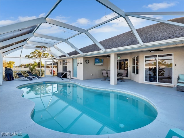 view of swimming pool featuring ceiling fan, a lanai, and a patio