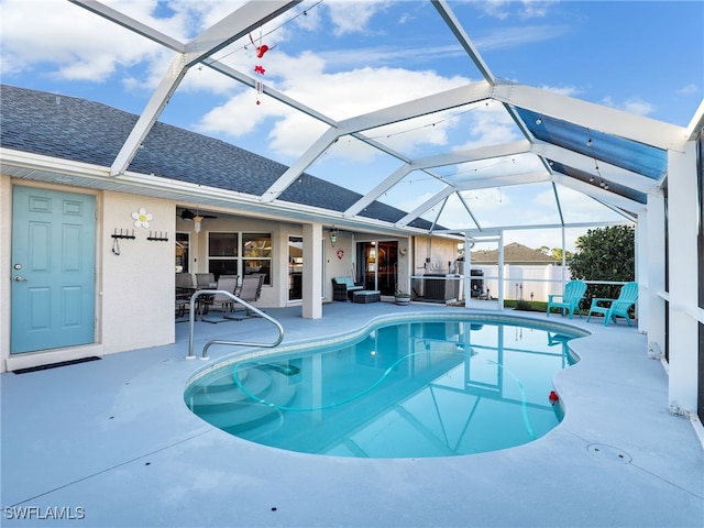 view of swimming pool featuring a lanai, a patio area, and ceiling fan