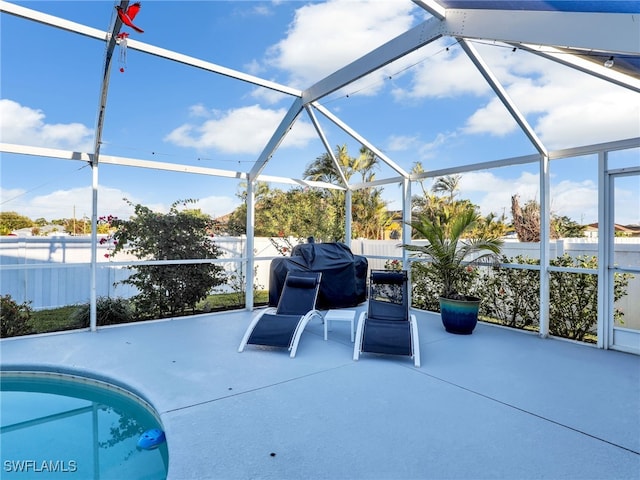 view of patio featuring a grill, a fenced in pool, and glass enclosure