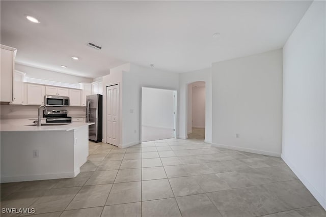 kitchen featuring white cabinetry, stainless steel appliances, kitchen peninsula, and sink