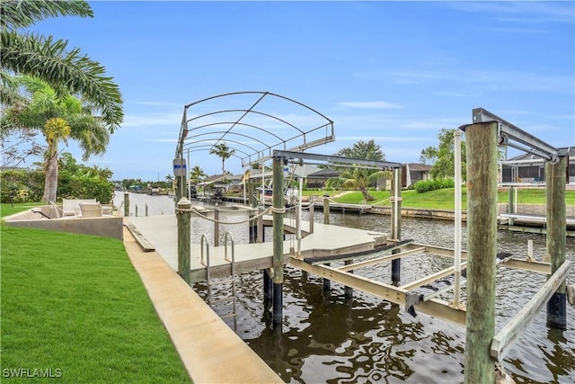 view of dock featuring a water view, a lawn, and boat lift