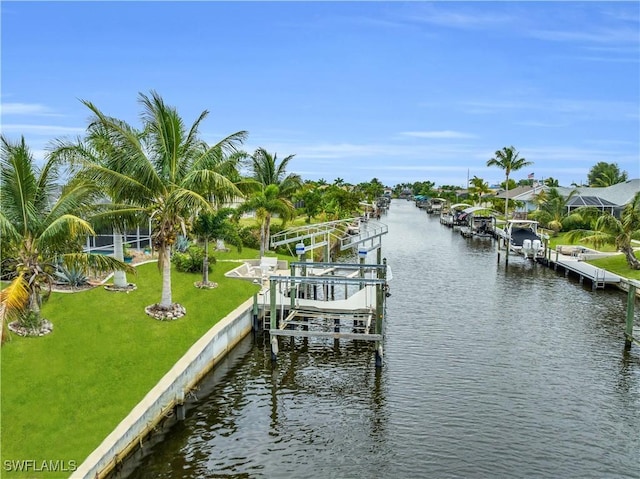 dock area with a water view, boat lift, and a yard