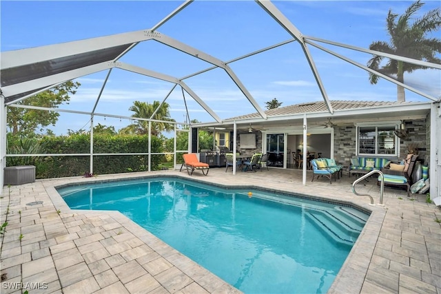 outdoor pool featuring glass enclosure, outdoor lounge area, a patio area, and a ceiling fan