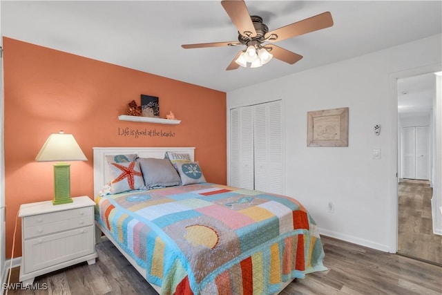 bedroom with a closet, ceiling fan, baseboards, and wood finished floors