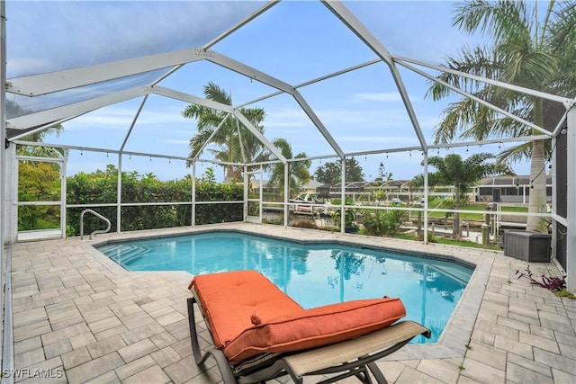 outdoor pool with glass enclosure and a patio area