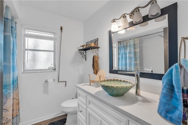 full bathroom with toilet, baseboards, wood finished floors, and vanity