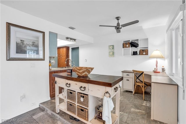 office space featuring a ceiling fan, visible vents, and a sink