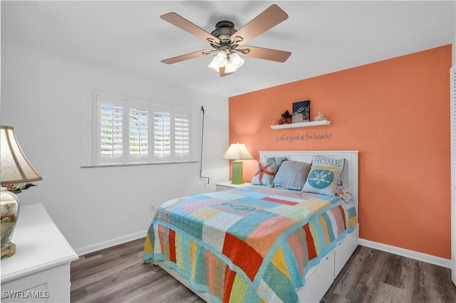 bedroom featuring a ceiling fan, baseboards, and wood finished floors