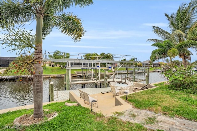 dock area featuring a water view, a lawn, and boat lift