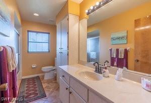 595 103rd Ave, Naples, FL 34108 - full bath featuring vanity, baseboards, walk in shower, and toilet