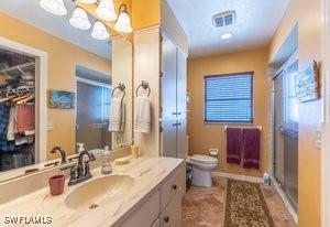 595 103rd Ave, Naples, FL 34108 - bathroom with toilet, a shower stall, and vanity