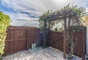 595 103rd Ave, Naples, FL 34108 - view of gate featuring a patio and fence