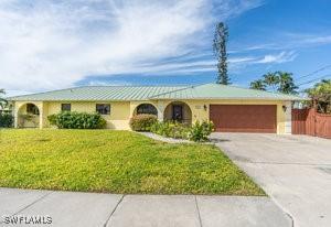 single story home featuring a garage and a front lawn