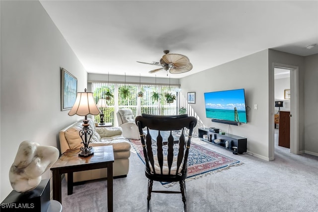 living area featuring carpet floors, a ceiling fan, and baseboards