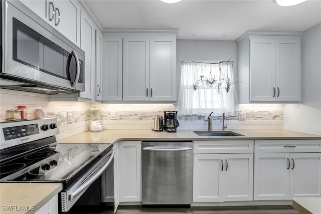 kitchen with appliances with stainless steel finishes, light countertops, and white cabinets