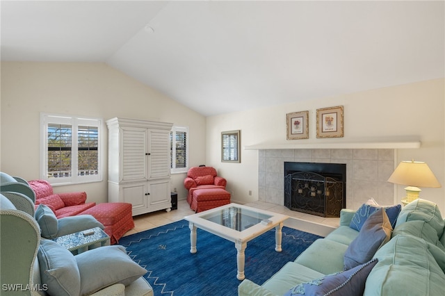 living area featuring light tile patterned flooring, vaulted ceiling, and a tile fireplace