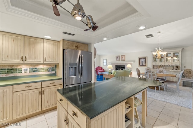 kitchen featuring light tile patterned floors, a tray ceiling, stainless steel refrigerator with ice dispenser, and visible vents