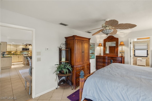 bedroom featuring light tile patterned floors, ceiling fan, ensuite bathroom, visible vents, and baseboards