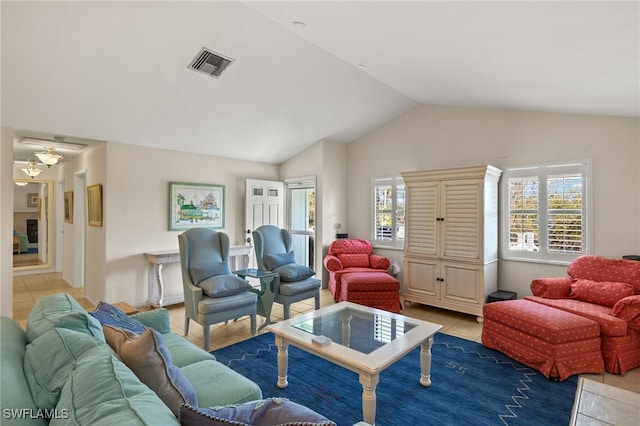 living area featuring lofted ceiling, plenty of natural light, visible vents, and light tile patterned flooring