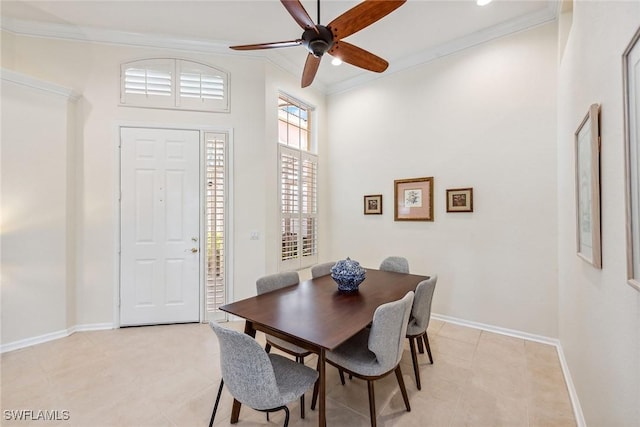 tiled dining area with ceiling fan and ornamental molding