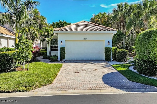 mediterranean / spanish house with a garage and a front yard