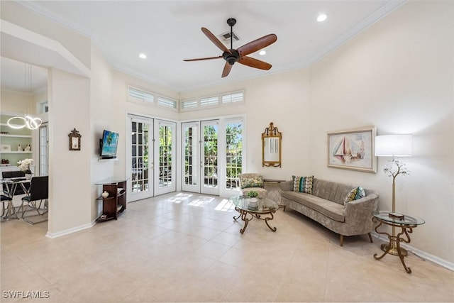 tiled living room with ornamental molding, a towering ceiling, ceiling fan, and french doors