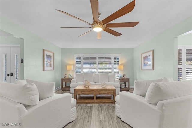 living room featuring ceiling fan and light hardwood / wood-style flooring