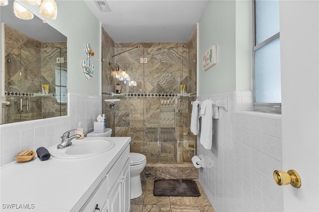 bathroom featuring toilet, tile walls, vanity, and walk in shower