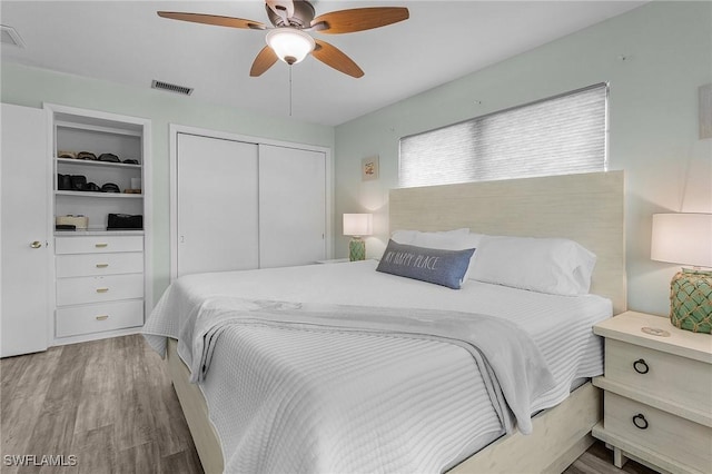 bedroom featuring hardwood / wood-style floors, a closet, and ceiling fan