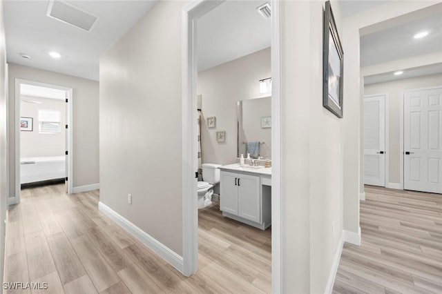 hallway featuring light hardwood / wood-style flooring and sink