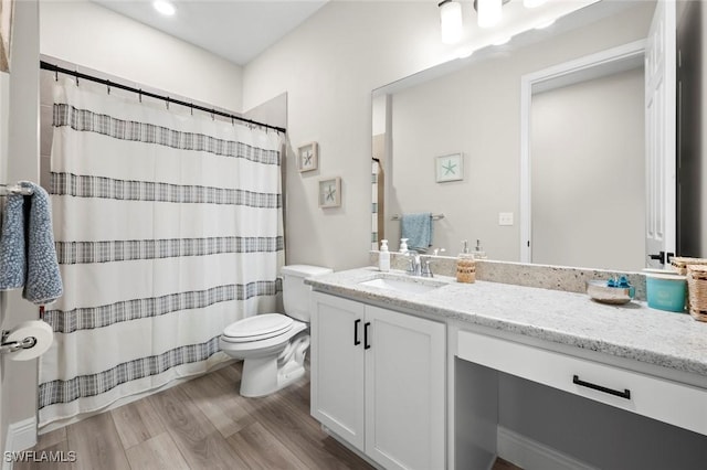 bathroom with toilet, wood-type flooring, and vanity