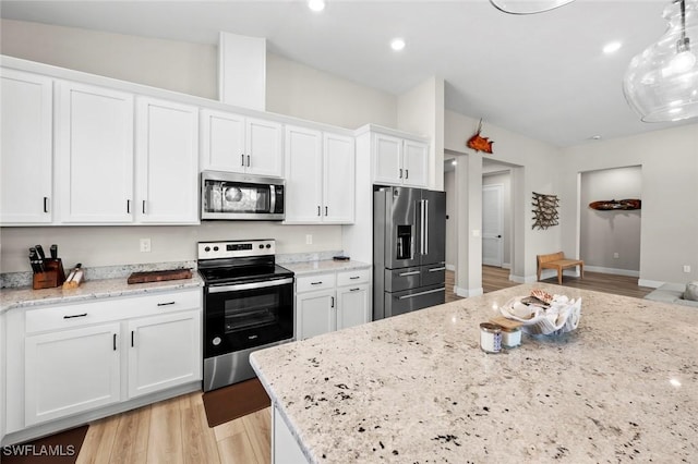 kitchen featuring decorative light fixtures, light stone countertops, light hardwood / wood-style floors, appliances with stainless steel finishes, and white cabinets