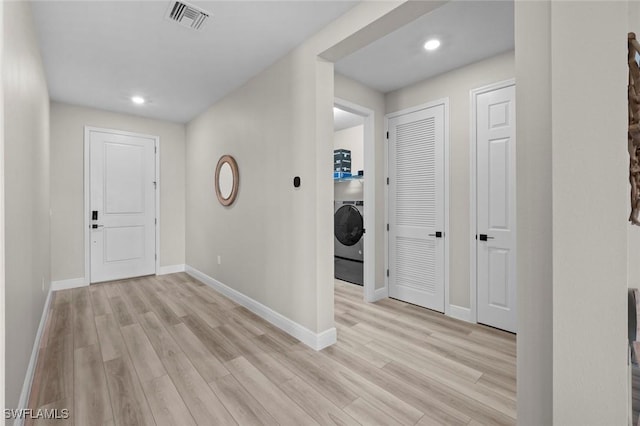 foyer with washer / clothes dryer and light hardwood / wood-style floors