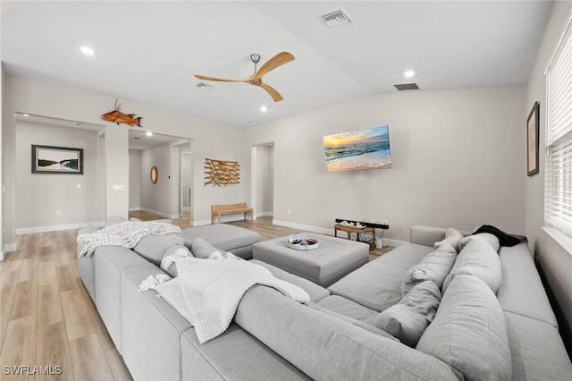 living room featuring light wood-type flooring, vaulted ceiling, and ceiling fan