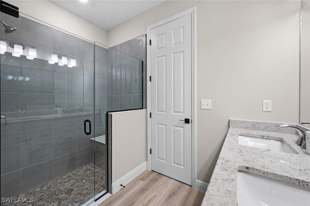 bathroom with hardwood / wood-style floors, vanity, and walk in shower