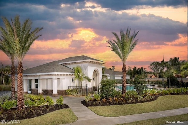 view of front of home featuring a yard and a fenced in pool