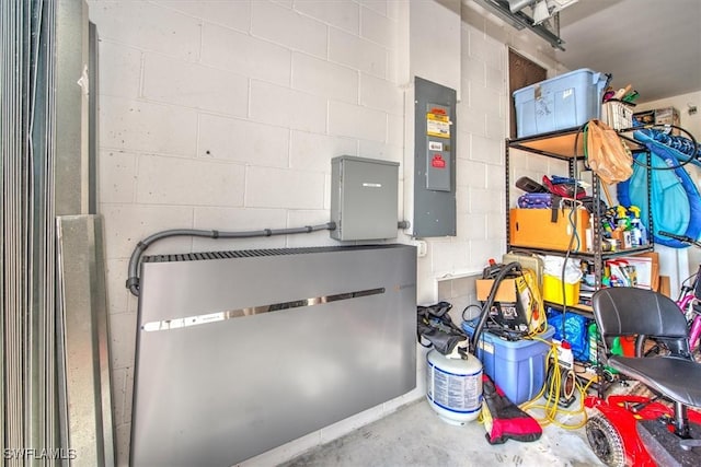 interior space featuring concrete flooring, concrete block wall, and electric panel