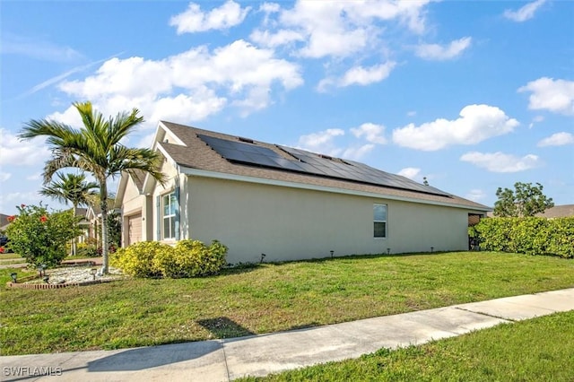 view of property exterior featuring a garage, solar panels, a lawn, and stucco siding