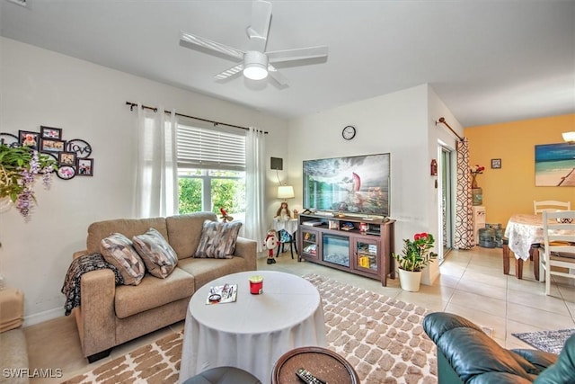 living area featuring light tile patterned floors and ceiling fan