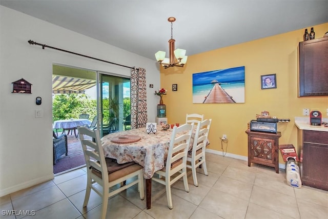 dining area with light tile patterned floors, baseboards, and an inviting chandelier