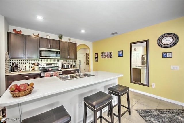 2733 Merida Ln, Cape Coral, FL 33909 - kitchen featuring visible vents, a breakfast bar, a sink, stainless steel appliances, and decorative backsplash